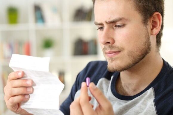 un hombre estudia el prospecto de un antibiótico para la prostatitis